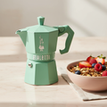 Bialetti Moka Express verde menta con ciotola muesli e frutti rossi – foto editoriale aesthetic